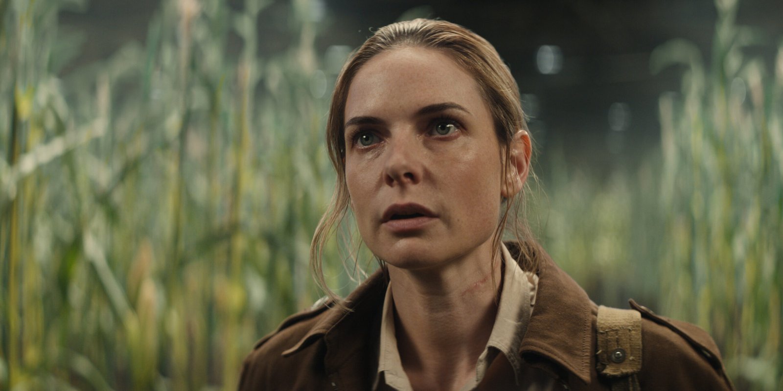 Juliette Nichols, played by Rebecca Ferguson, standing among green plants in Silo